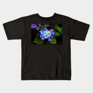 Close-up of a hydrangea with blue buds and flowers as well as green foliage Kids T-Shirt